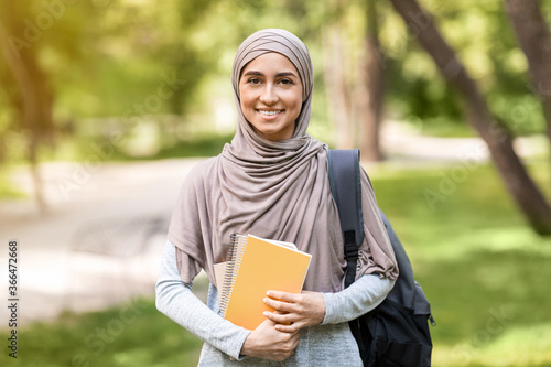 Canvas Print Pretty arab girl student walking by park after school