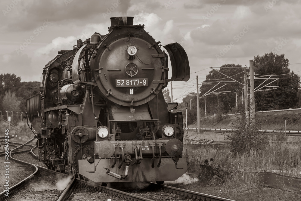 Naklejka premium Steam Locomotive, german Steam Locomotive, Steam Locomotive and big Clouds in Background, black and white photo