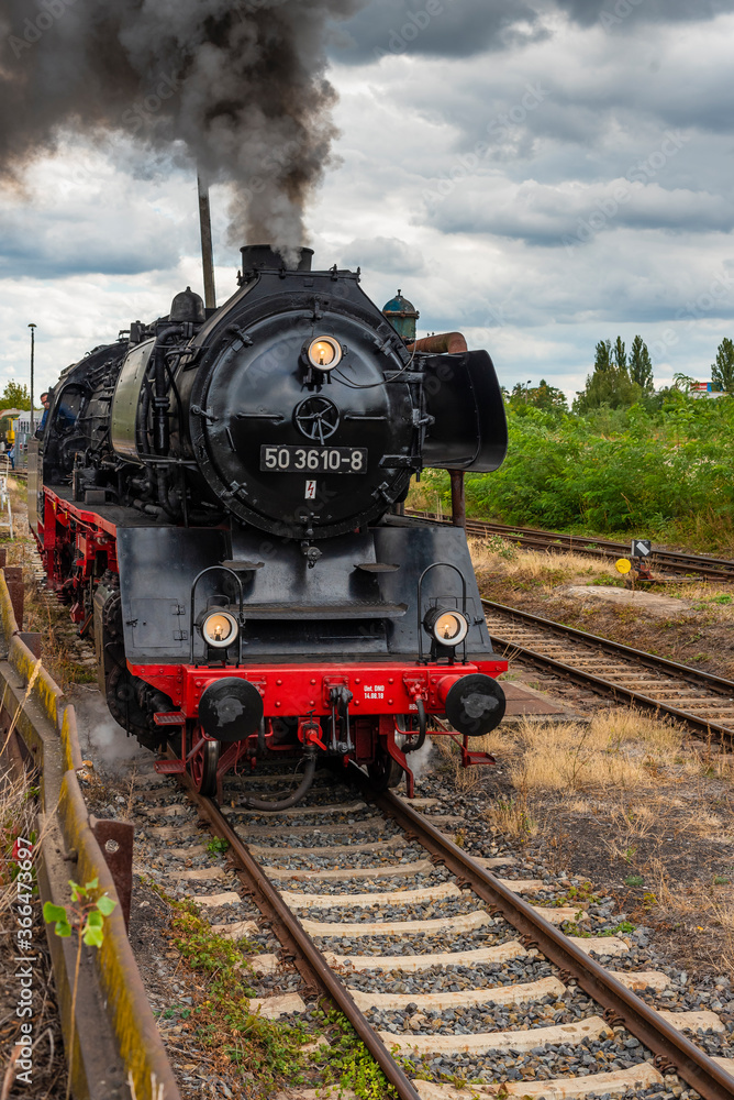 Obraz premium Steam Locomotive, german Steam Locomotive, Steam Locomotive and big Clouds in Background