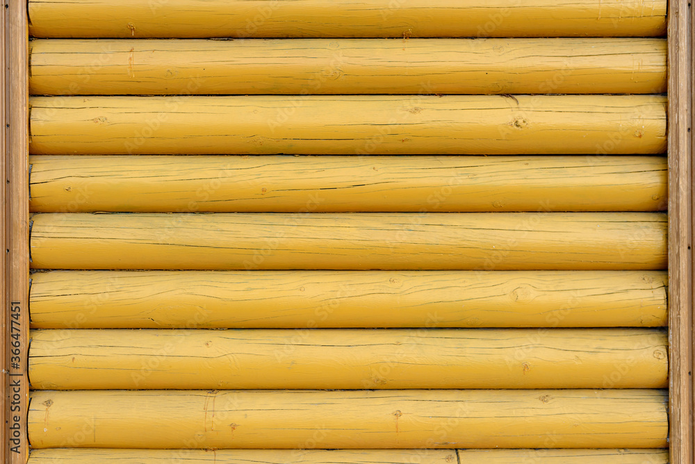 The wall of the building is made of wooden logs painted with yellow paint. A modern building in classical Slavic architecture The wall of the building is made of wooden logs painted with yellow paint. A modern building in classical Slavic architecture