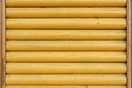 The wall of the building is made of wooden logs painted with yellow paint. A modern building in classical Slavic architecture