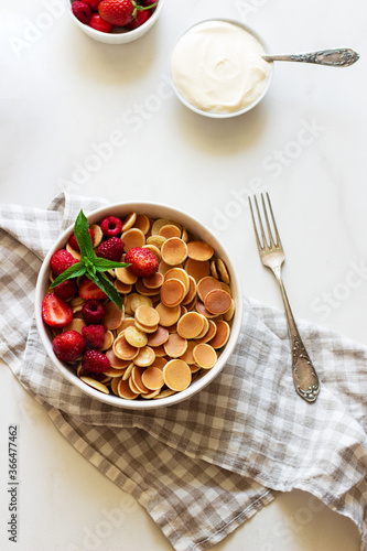 Mini pancake cereal with berry and mint leaves on white background.