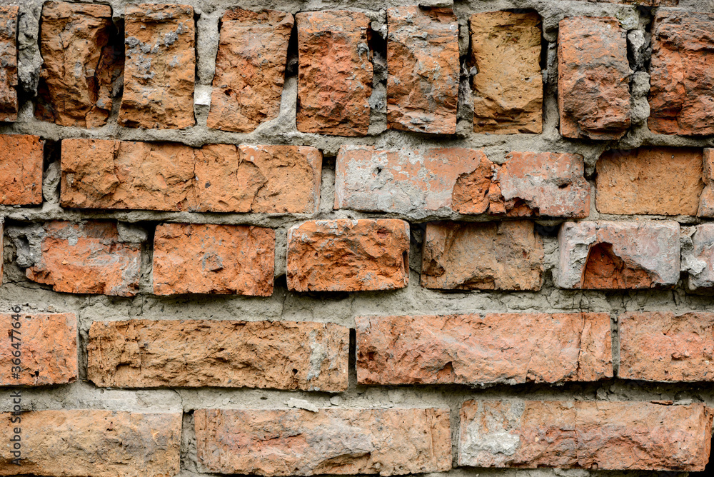 A wall of very old brick red-orange and brown with destruction. Texture A wall of very old brick red-orange and brown with destruction. Texture