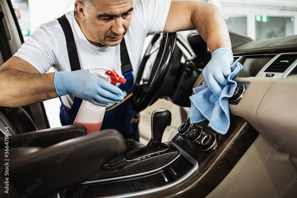 Car wash service worker wet cleaning expensive and luxurious vehicle interior and seats Car wash service worker wet cleaning expensive and luxurious vehicle interior and seats