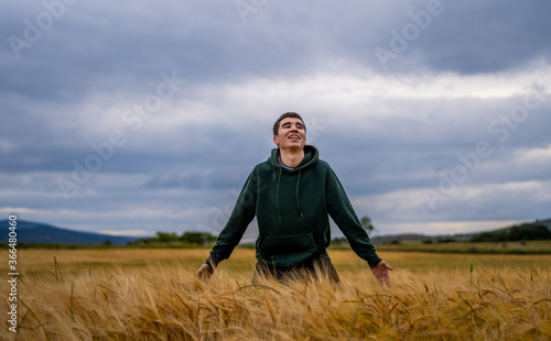 a boy in sportswear in a wheat field walks and runs happily into a sunset. © JuanFrancisco