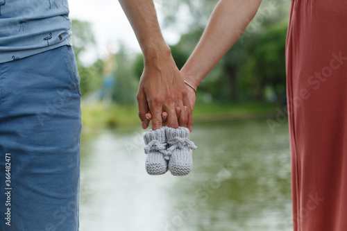 Mother and father (man and woman) are holding hand-knitted baby booties