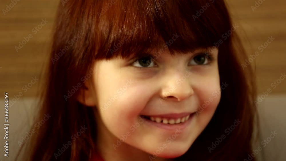 Cute excited happy little girl child kid looking at huge present gift box smiling waiting to open in close up shot Cute excited happy little girl child kid looking at huge present gift box smiling waiting to open in close up shot