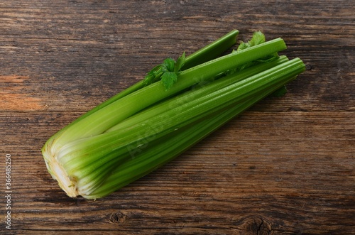 Bunch of fresh celery stalk with leaves on old wooden background photo