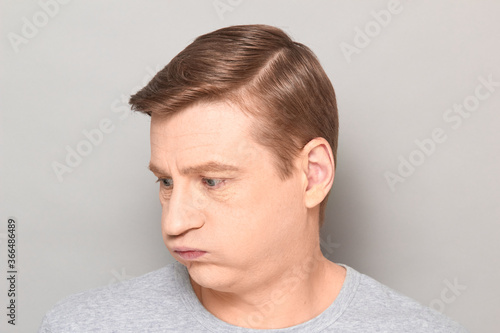 Portrait of disappointed man sighing sadly, looking tired and bored