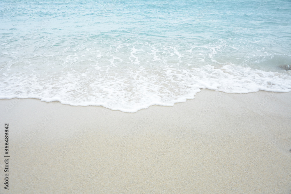 Soft wave of turquoise sea water on the sandy beach