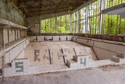 Obraz na płótnie empty and destroyed olympic pool in ancient village shaken by Chernobyl explosion w salonie