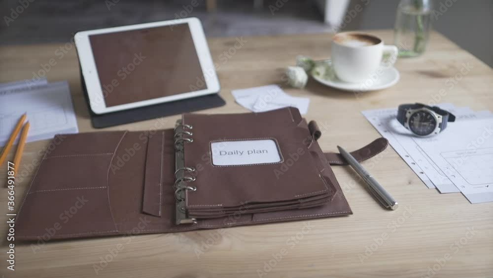 Beautiful close up view on business work area desktop with tablet cell phone coffee mug watch leather planner journal Beautiful close up view on business work area desktop with tablet cell phone coffee mug watch leather planner journal