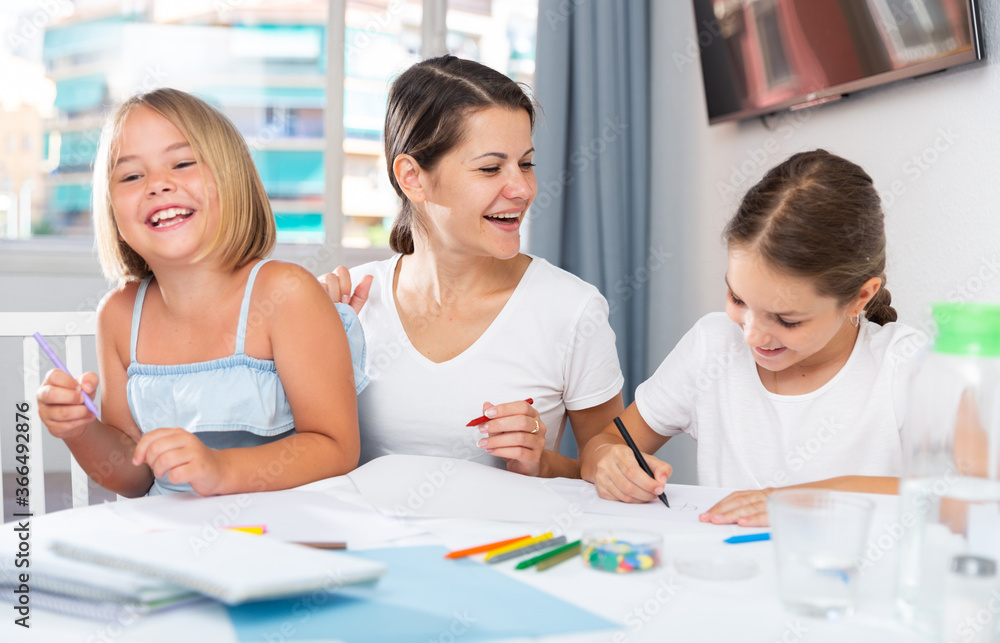 Obraz premium Mother and two children together with wax crayons in home