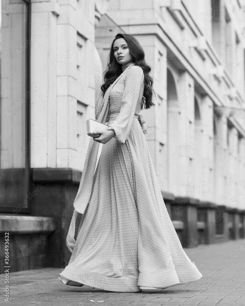 Fashion outdoor portrait. Young stylish woman in long pink evening dress walking at city street on a summer day. Full length Fashion outdoor portrait. Young stylish woman in long pink evening dress walking at city street on a summer day. Full length