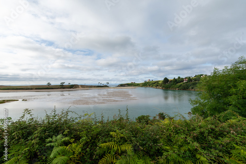 Horizontal view of the Ria de la Rabia  a cloudy afternoon  with vegetation  in the Oyambre natural park in Cantabria  horizontal