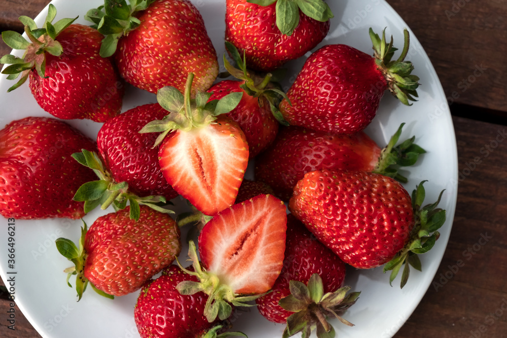 Ripe fresh strawberries on a white plate close-up. Ripe fresh strawberries on a white plate close-up.