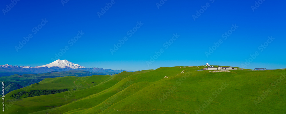 Green Meadow Hills background Elbrus at a Summer Day. Panorama Green Meadow Hills background Elbrus at a Summer Day. Panorama