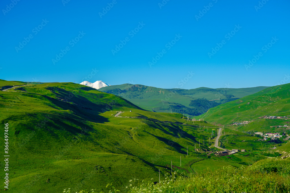 Elbrus and Green Meadow Hills at a Summer Day. North Caucasus, Russia