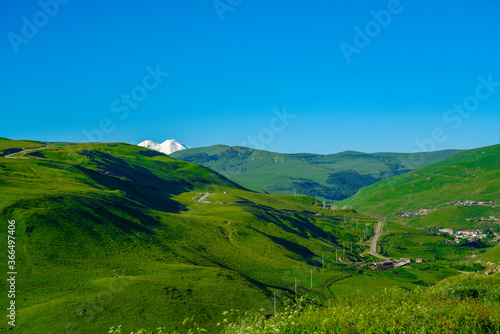 Elbrus and Green Meadow Hills at a Summer Day. North Caucasus, Russia