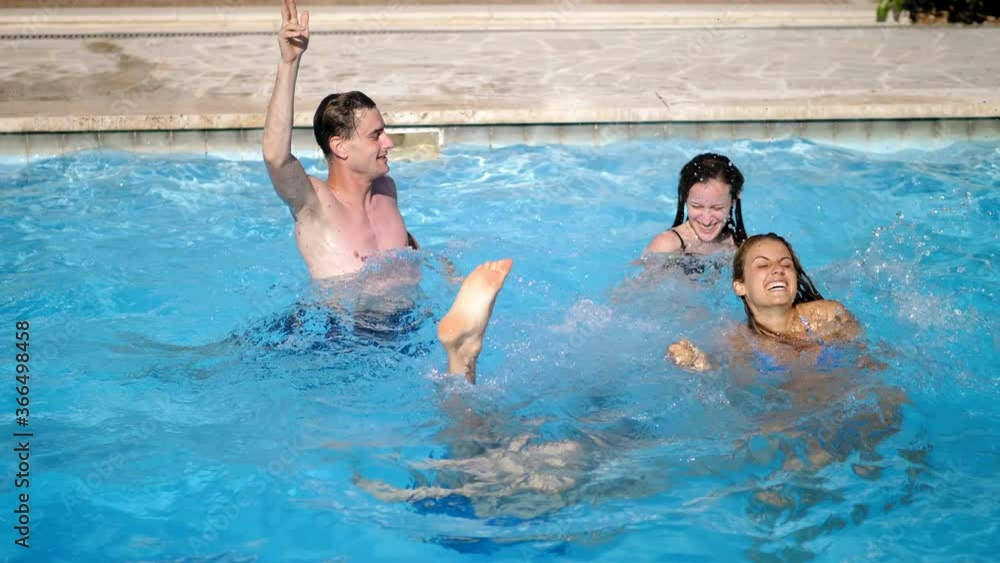 Group of happy friends playing in swimming pool. Summertime,holidays, happiness Group of happy friends playing in swimming pool. Summertime,holidays, happiness