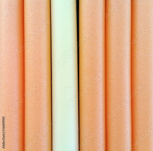 Colorful pool noodles, to be used in the water, to help float and swim. Flotation device. Safety equipment.