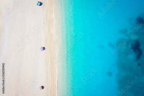 Luftaufnahme des beliebten Strandes von Myrtos mit ruhigem, türkisfarbendem Meer und Sonnenschirmen am feinem Kiestrand im Sommer, Kefalonia, Griechenland © moofushi