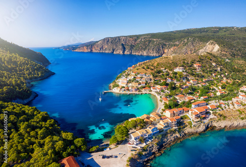 Luftaufnahme des kleinen Dorfes von Assos, Kefalonia, Griechenland, mit türkisfarbendem Meer und roten Dächern der bunten Häuser nah an der Küste und Strand © moofushi