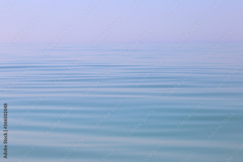 Calm sea wavy surface of the sea under a clear sky close-up. Blue background. Calm sea wavy surface of the sea under a clear sky close-up. Blue background.