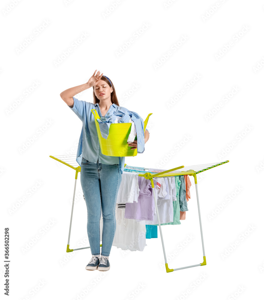 Tired woman with clean clothes and dryer on white background
