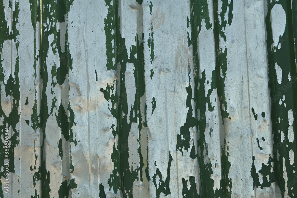 A sheet of metal profile with peeled green paint.