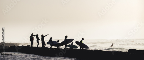group of people having fun together entering to the water at the beach to surfing - surfers enjoying summer and ocean - vacations and holiday or journey concept © Fabio