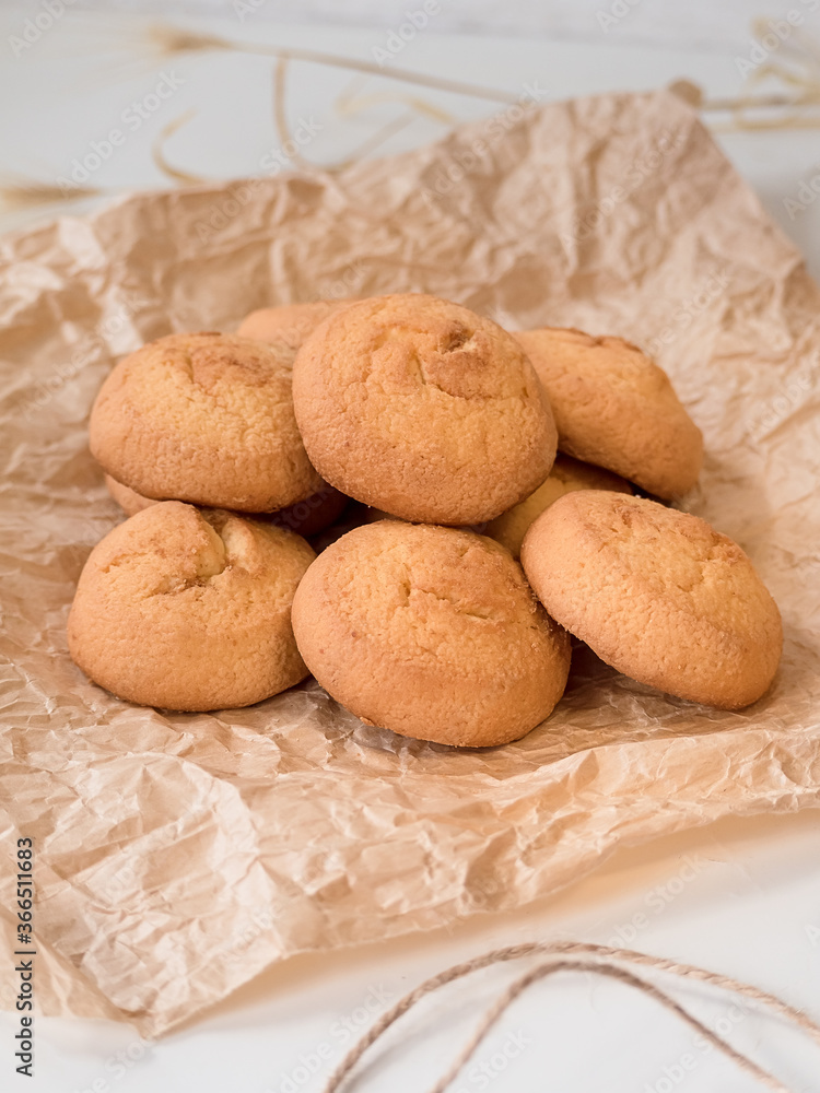 a lot of round cheese biscuit biscuits on crumpled parchment paper and a scourge close-up a lot of round cheese biscuit biscuits on crumpled parchment paper and a scourge close-up