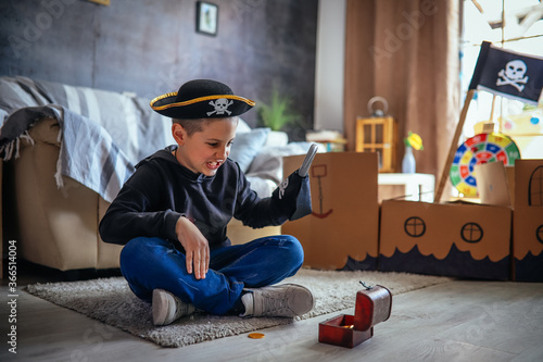 The boy is happy that he found a suitcase with gold. And out of happiness he swings a pirate hook and screams