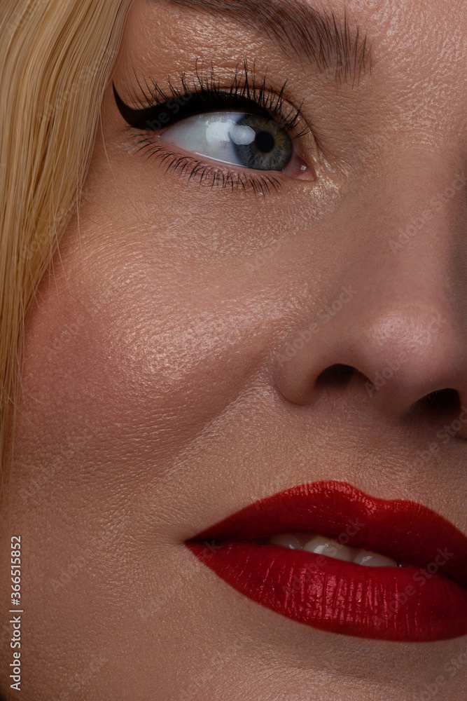 Naklejka premium Beautiful portrait of a female face. A beautiful mature model with perfect clear skin, red lips, long eyelashes and arrows. Blond long hair youth and skin care concept. anti-aging effect