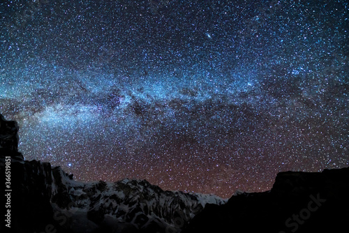Obraz na płótnie Milky Way and mountains. Amazing scene with Himalayan mountains and starry sky at night in Nepal. Rocks with snowy peak and sky with stars. Annapurna Range. Night landscape with bright milky way w salonie
