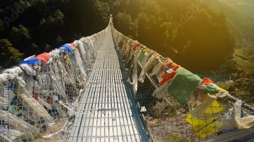Point of view shot - Crossing a Hillary suspension bridge on the Everest Base camp trek in the Himalaya, Nepal. Himalaya landscape and mountain views.
