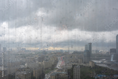 a view of a big city through the window where you can see that it is raining outside