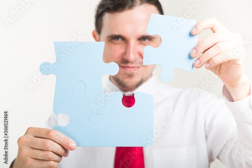 Smiling Businessman Combining Puzzle Pieces Together
