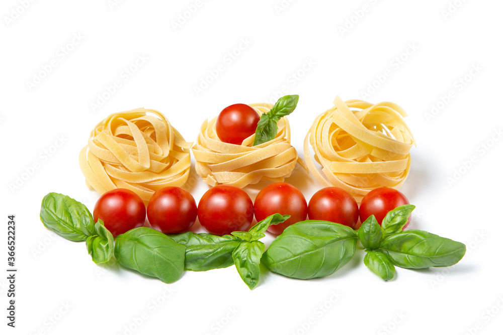 Cherry tomatoes, pasta and basil leaves on a white isolated background. Copy space. Gamedients for dinner. Cherry tomatoes, pasta and basil leaves on a white isolated background. Copy space. Gamedients for dinner.
