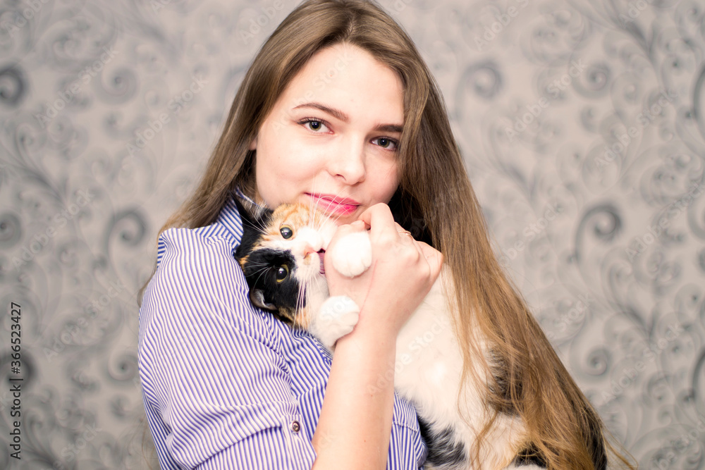 Obraz premium Portrait of a girl with a cat in her hands.