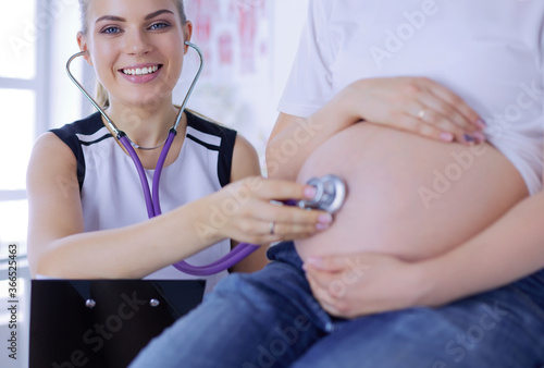 Young female doctor examining pregnant woman at the clinic.