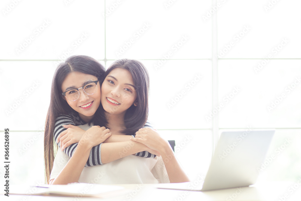 Obraz premium Portrait smiling young asian lesbian couple hugging each other while sitting together on work at home time. LGBT Lesbian couple love moment.