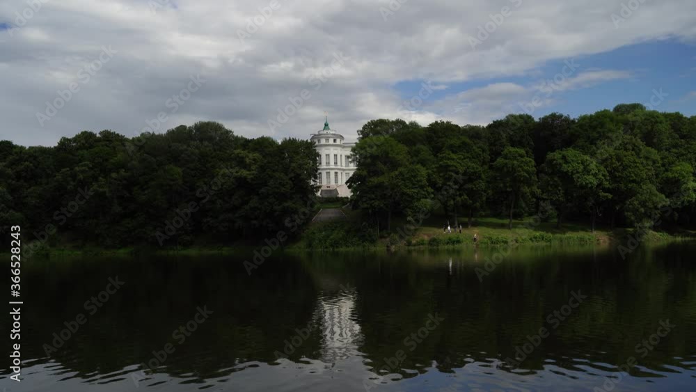 Beautiful landscape of park with manor in summertime. Picturesque place of white Palace with pond and green trees. Beautiful landscape of park with manor in summertime. Picturesque place of white Palace with pond and green trees.