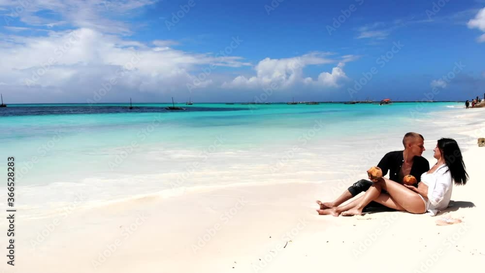 Amazing exotic place with white sand beach and turquoise water, unforgettable honeymoon vacation of young couple in love. Just married couple lying on sand beach and kissing, ocean water surrounding Amazing exotic place with white sand beach and turquoise water, unforgettable honeymoon vacation of young couple in love. Just married couple lying on sand beach and kissing, ocean water surrounding