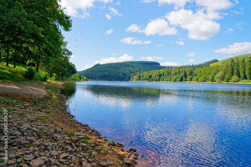 Looking up Derwent Reservoir from a rocky shore on a hazy day