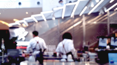 blurred view of two baristas brewing coffee at modern coffee store. abstract business background.