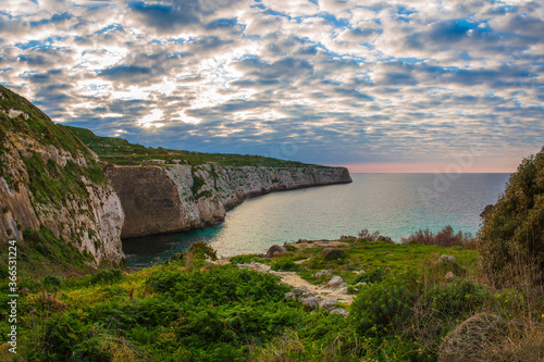 Obraz na plátně Colourful clouds saturate the background at Fomm ir-Rih, Malta