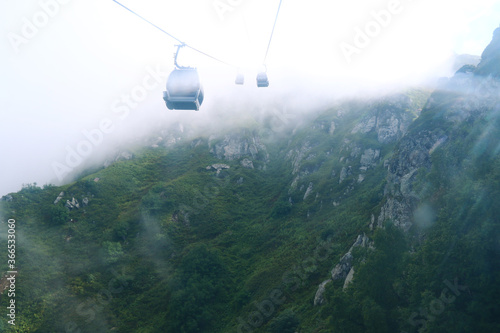 cable car in mountains with cloud or fog
