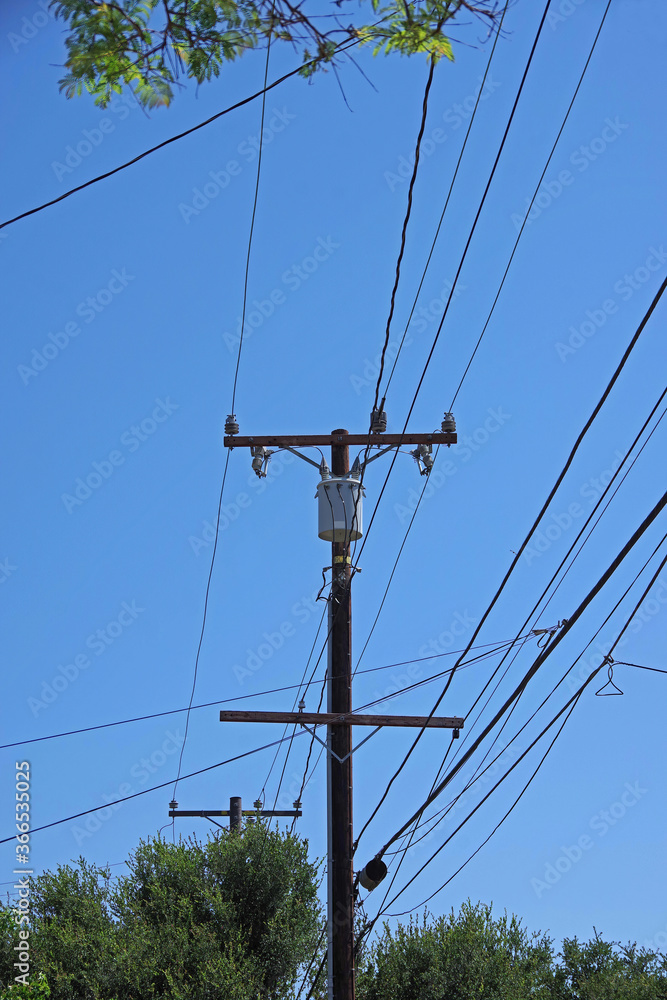 Electricity distribution pylon, power lines, trees and blue sky Electricity distribution pylon, power lines, trees and blue sky