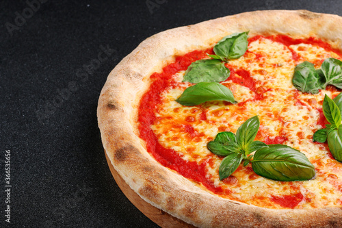 Pizza Margherita with tomatoes, Basil and Mozzarella Cheese closeup on dark concrete table or stone background